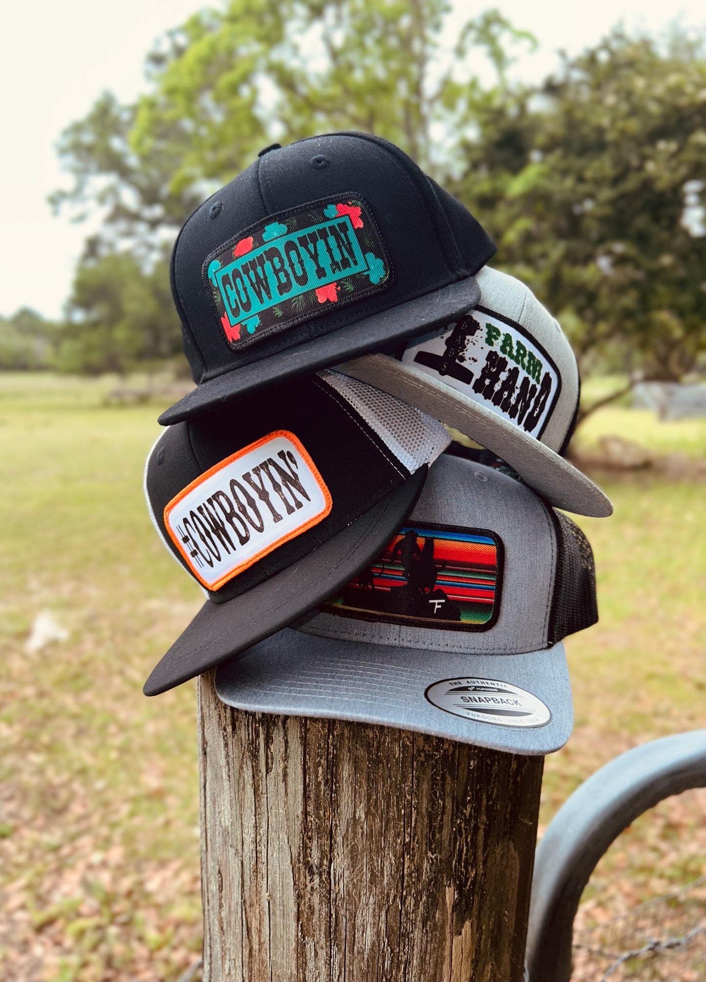  A stack of hats resting on a wooden post in a rustic setting